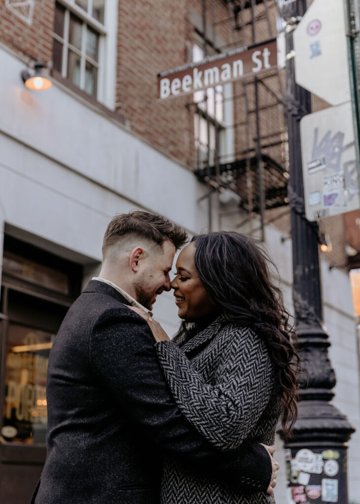 New York couple posing in front of a building for their New York City engagement photos