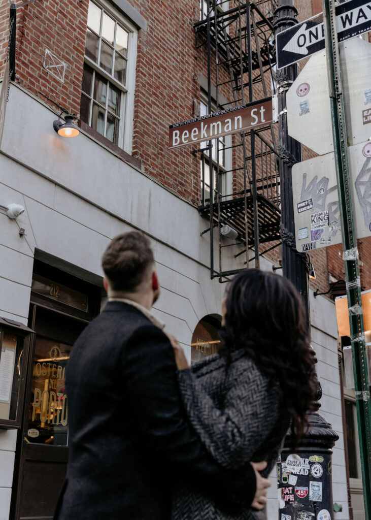 New York couple posing in front of a building for their New York City engagement photos