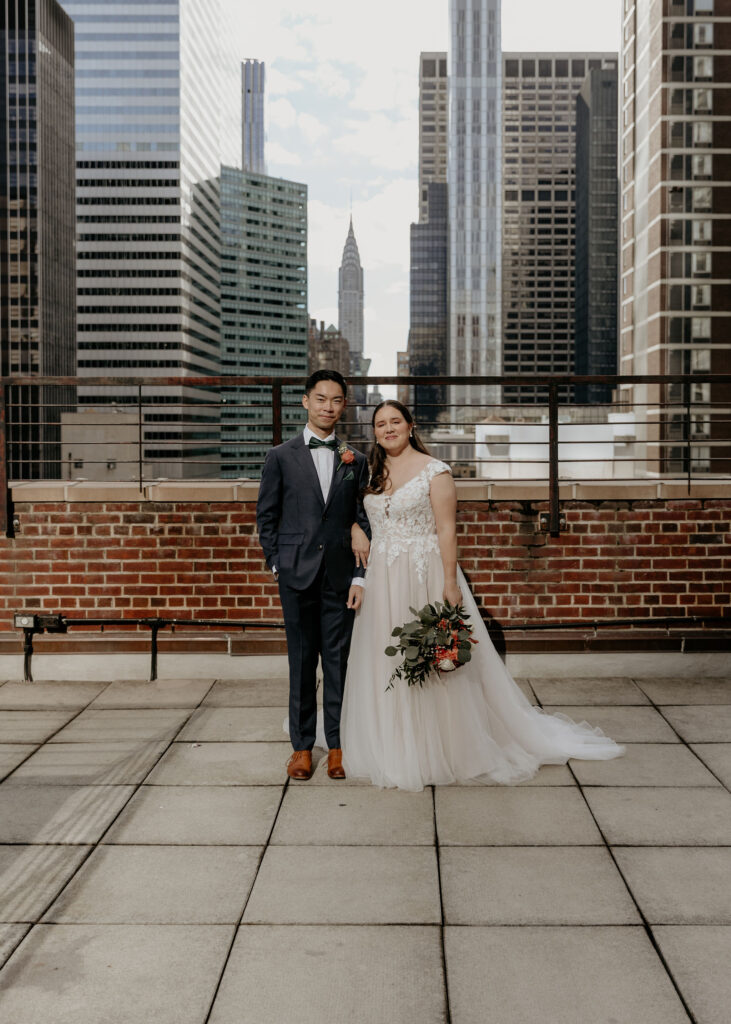 Beautiful Bride and groom standing on Tribeca Rooftop with New York Skyline in the background