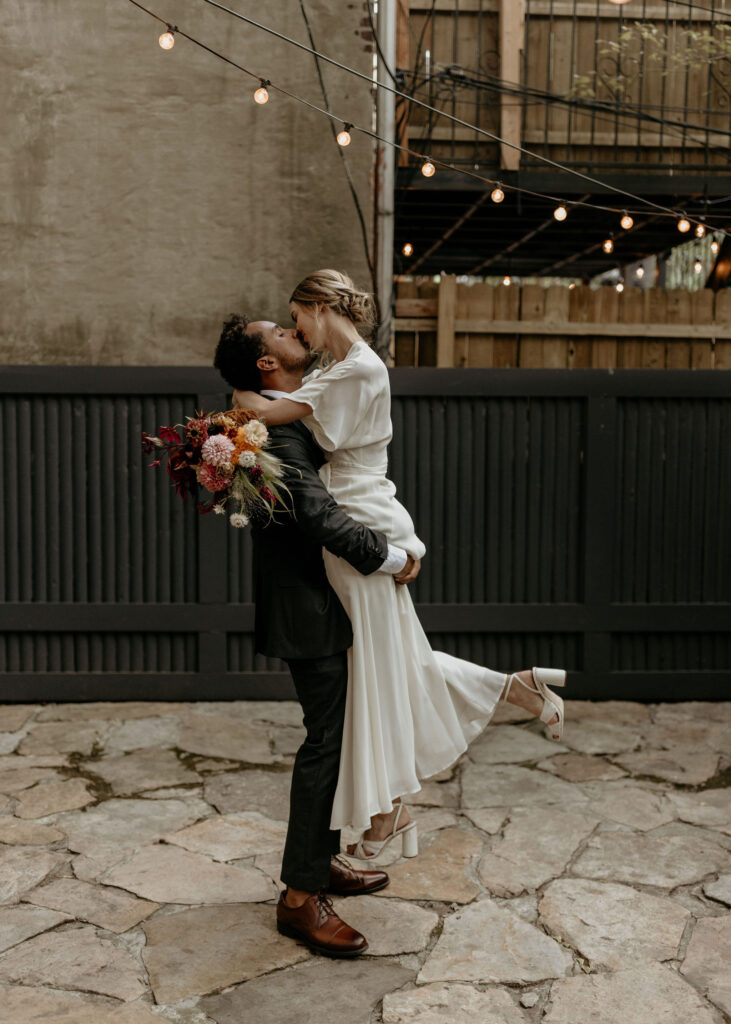 Romantic bride and groom kiss at Maison May during their intimate wedding in New York