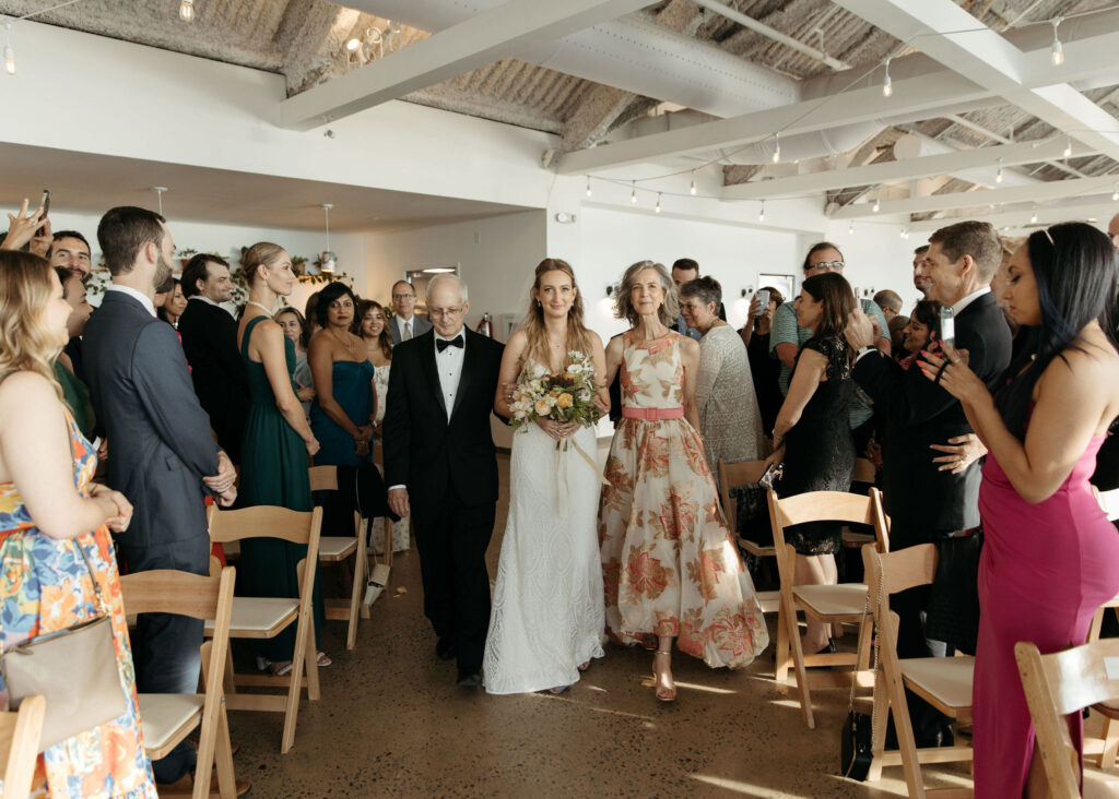 bride walking down the aisle with her parents