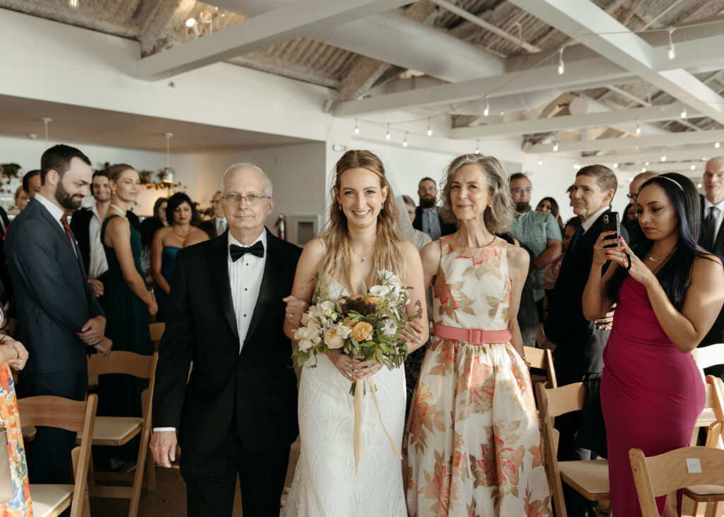 bride walking down the aisle with her parents