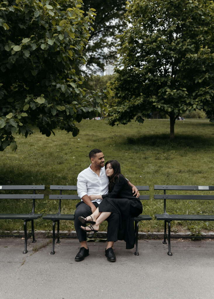 intimate Central park engagement photo with the couple sitting on the bench