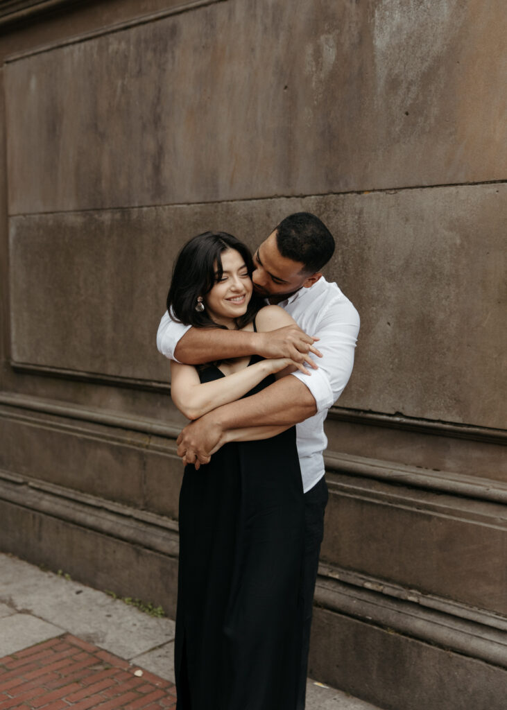 Playful Central park engagement photos at Bethesda terrace with sleek black dress and classy casual vibes